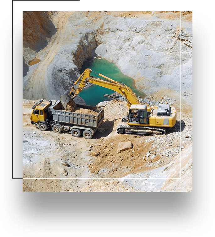 A dump truck and a tractor in the dirt.