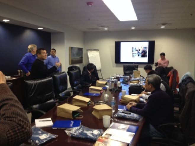 A group of people sitting around a conference room.