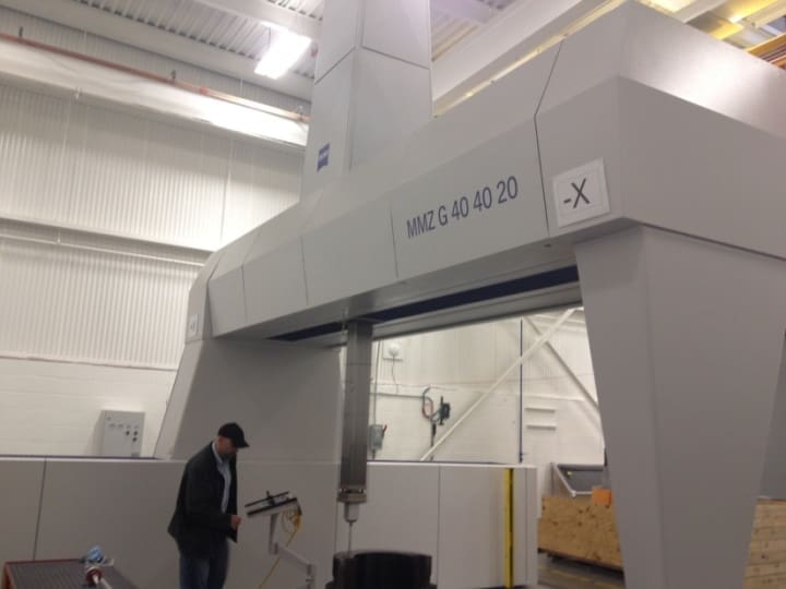 A man in a suit and tie standing next to a machine.