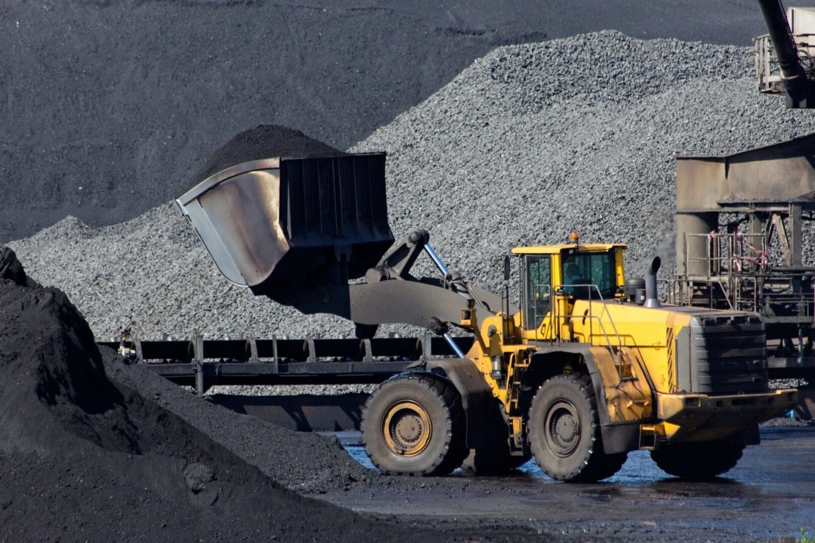 A large yellow and black truck is parked in the dirt