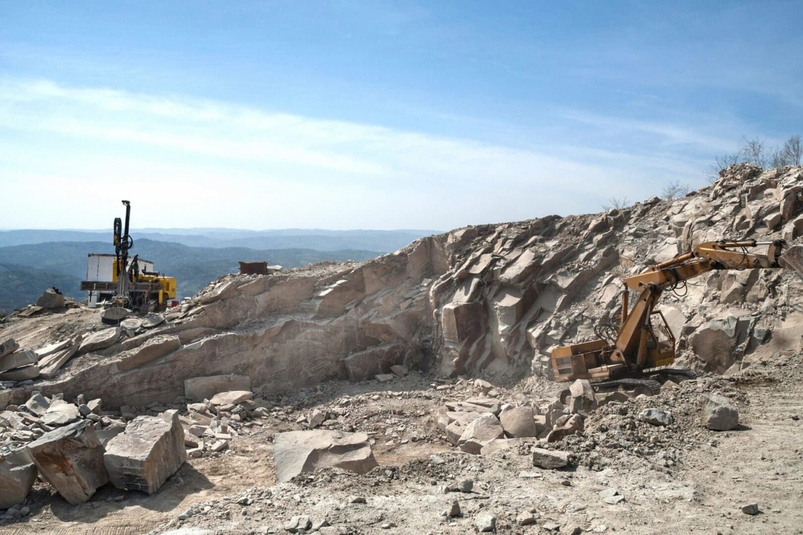 A large rock pile with a bulldozer on it.