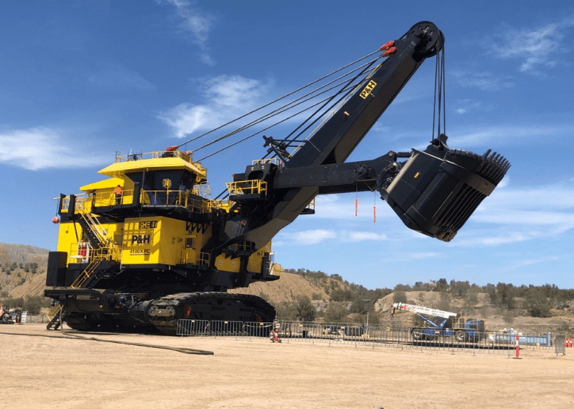 A large yellow and black machine on the sand.