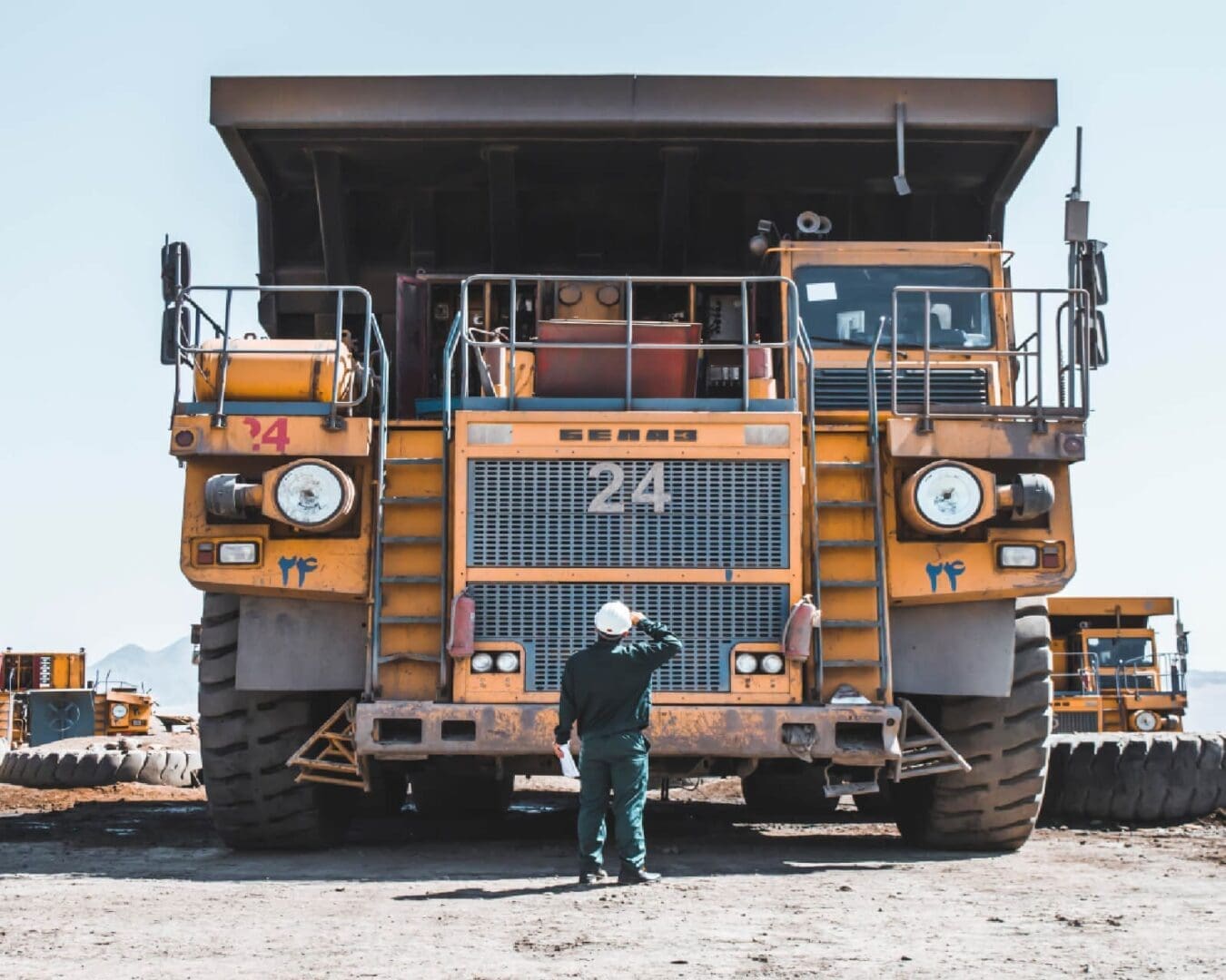 A man standing in front of an old dump truck.